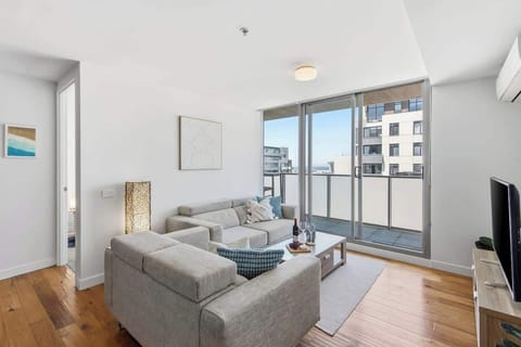 Bright, modern living space with sleek furnishings—perfect for unwinding after a day out, streaming your favorite shows, or enjoying the natural light through floor‑to‑ceiling doors.