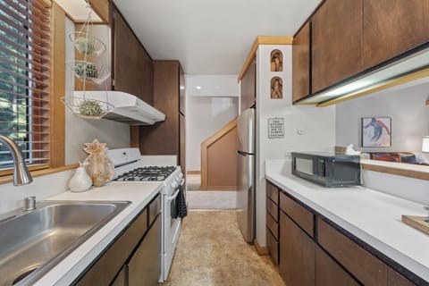A warm, wood-accented galley kitchen with generous prep space and a charming cabin feel.
