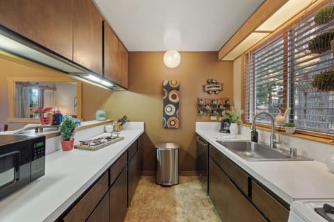 A warm, wood-accented galley kitchen with generous prep space and a charming cabin feel.