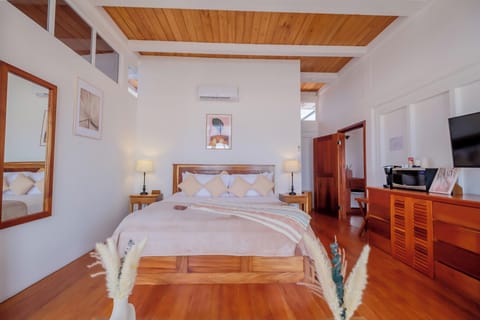 Sink into plush bedding beneath high ceilings and coastal calm.