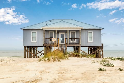 Beachfront retreat on stilts offers direct beach access with stunning coastal views and natural dune surroundings.