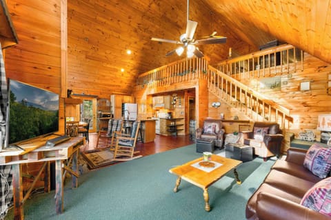 Open-concept living with a cozy stone fireplace, soaring ceilings, and mountain charm.