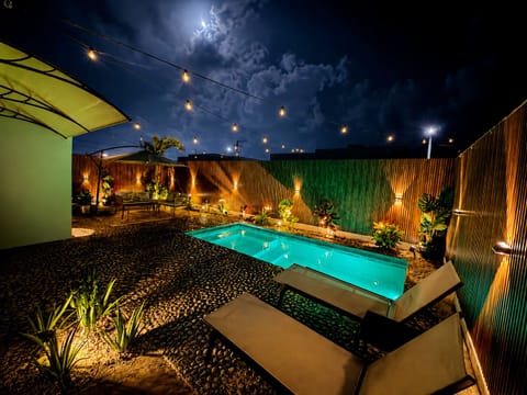 Moonlit oasis with a private pool, tropical ambiance, and cozy outdoor retreat under the stars.