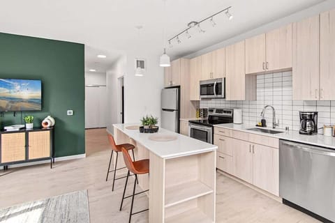 Bright, modern kitchen with light wood cabinetry, stainless steel appliances, and a spacious island — perfect for cooking or entertaining.
