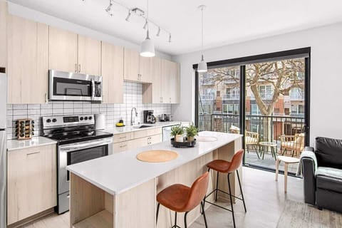 Bright, modern kitchen with light wood cabinetry, stainless steel appliances, and a spacious island — perfect for cooking or entertaining.