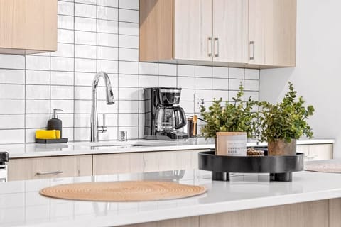 Elegant kitchen island décor featuring modern greenery and neutral accents — a perfect touch of freshness that complements the bright, airy design of this open kitchen space.