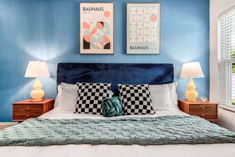 Warm, stylish retreat featuring Bauhaus art, golden bedside lamps, and a plush king bed for restful nights.