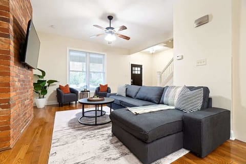 Spacious living area with a modern sectional sofa, cozy lighting, and open-concept flow — perfect for relaxing or entertaining guests.