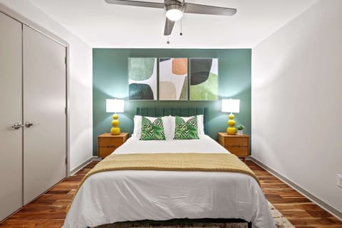 Stylish and inviting room featuring a comfortable queen bed, soft ambient lighting, and a striking geometric accent wall that adds character and warmth. Perfect for relaxing nights and restful mornings. ✨🛏️