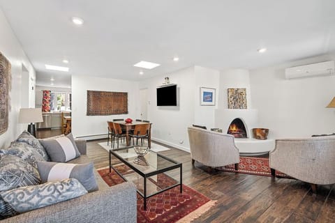 Relax in your stylish living room featuring a cozy fireplace, elegant furnishings, and warm wood floors—perfect for unwinding after exploring.