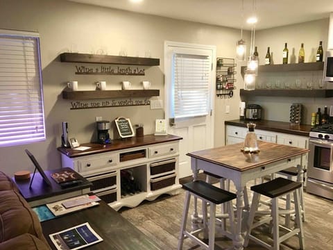 This delightful kitchen and dining area features a table perfect for two, complemented by a charming console for wine and coffee essentials. The stylish open shelving and modern appliances make this space both beautiful and fully functional for your stay.