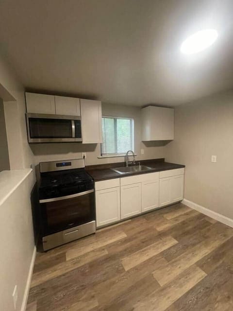 Whip up your favorite dishes in this fully equipped kitchen, featuring a sink, cabinets for storage, a refrigerator, an oven, and a stove. 