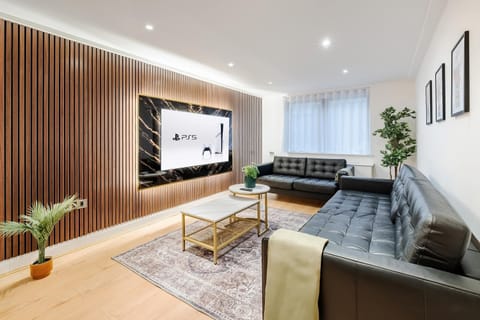 Living Room | Elevated luxury awaits in the living room, featuring a beautifully decorated space with a 70 inch smart TV, an open plan fully equipped kitchen, and a dining table seating up to 6 guests, perfect for sharing meals in comfort.