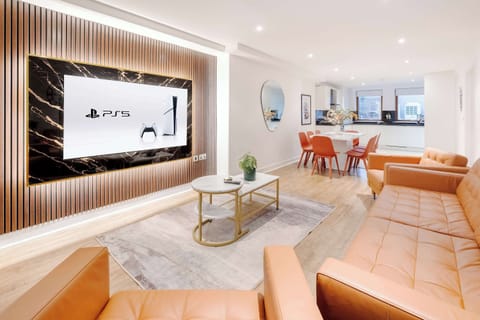 Living Room | Elevated luxury awaits in the living room, featuring a beautifully decorated space with a 75 inch smart TV, an open plan fully equipped kitchen, a dining table seating up to 8 guests, and a lovely balcony, a true hidden gem!