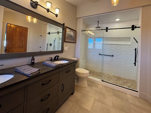 Private suite bathroom w/ double sink, walk-in shower w/rain and handheld heads