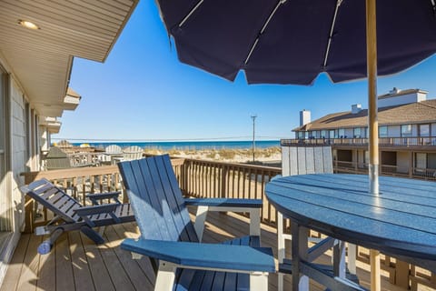 The bar-height table and umbrella create an inviting space for sunset drinks or leisurely afternoons outdoors.