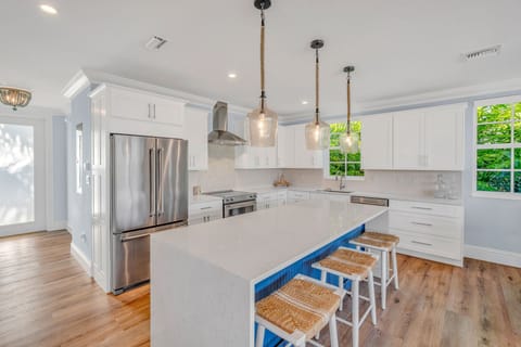 Spacious gourmet kitchen with high-end appliances, quartz counters, and water views—perfect for preparing meals during your Florida Keys luxury getaway.