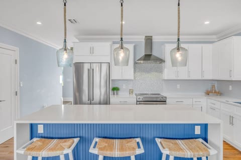 Fully equipped chef's kitchen featuring stainless steel appliances and an open layout overlooking the heated pool and gulf views.