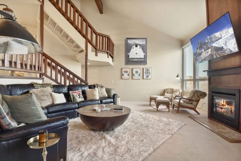 Sink into plush leather seating by your crackling fireplace, where mountain views and cozy textures create your perfect retreat.