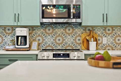 With its playful wallpaper and vibrant blue hues, this kitchen turns cooking into a colorful, creative experience.
