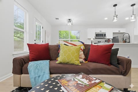 comfy and spacious living room with a long sofa for 3, chairs, ottoman. TV is 60 inch
