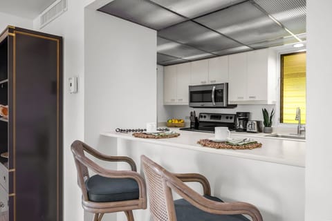 Bright kitchen seating area with white cabinetry and bar dining creates a welcoming space for casual meals and conversation