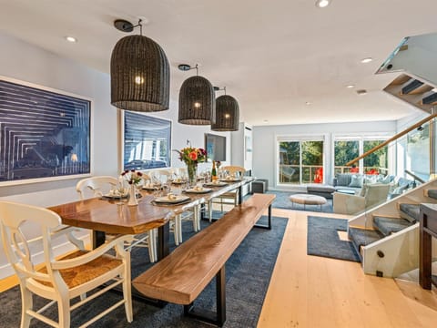 Beautiful open concept main living space with live-edge feature dining table, sunken living room, and kitchen with patios front and back.