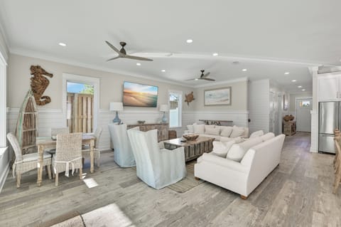Wide angle of the living space, highlighting the airy layout and ceiling fans.