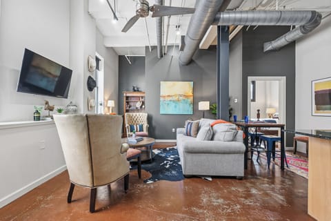 Open-plan living and kitchen area featuring warm western-inspired décor, high ceilings, and a spacious layout—perfect for relaxing, cooking, and gathering in comfort.