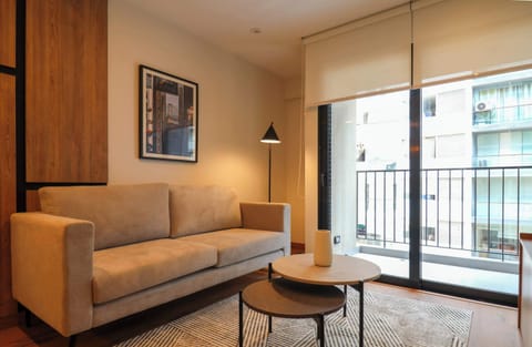 Bright living area with a comfortable sofa and direct access to the private balcony.