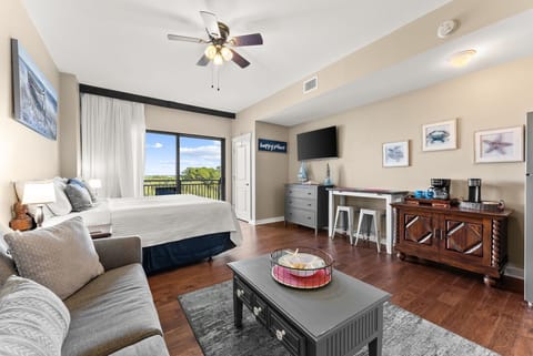 Spacious suite with cozy sofa, comfortable bed, and breakfast bar overlooking peaceful green views.