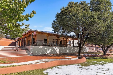 Traditional adobe home with mature fruit trees and grassy lawn