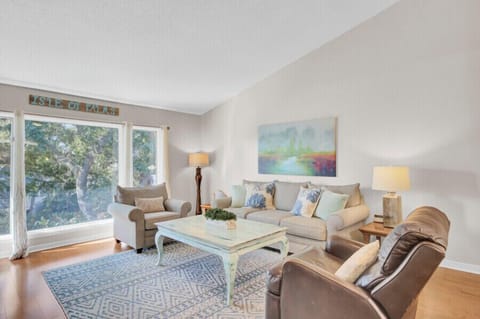 Unwind in your bright living space with plush seating, calming artwork, and peaceful garden views streaming through large windows.