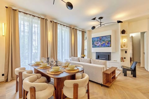 Salon avec canapé, table basse, TV et espace repas