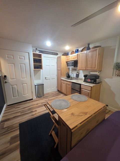 Fully stocked kitchenette w/ collapsible and extendable dining table and chairs.