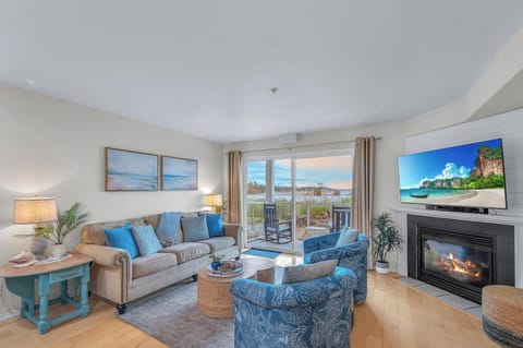 Unwind in this bright coastal living room with ocean views, cozy fireplace, and beachy decor perfect for your seaside retreat.