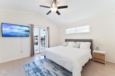 Primary bedroom with balcony access & TV