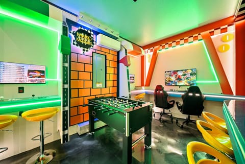 Immerse yourself in our vibrant game room filled with bold neon lights and playful decor. Enjoy gatherings on bright yellow bar stools and revel in the fun atmosphere created by retro-inspired walls and a foosball table.