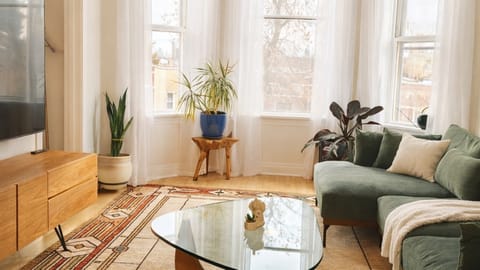 Bright and stylish living room with large windows, comfortable seating, and modern decor.