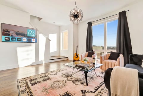 Living room guitar and armchairs create the laid-back vibe of a vacation rental built for friends and group celebrations