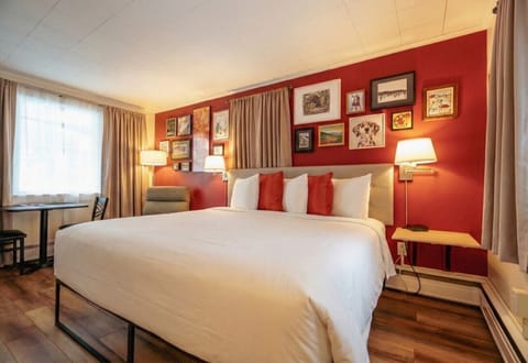 A bright bedroom with one king bed, crisp white linens, and a convenient in-room kitchenette.