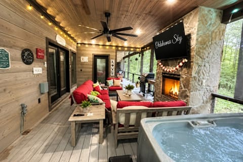 Relax on the covered patio with cozy seating, fireplace, and private hot tub und