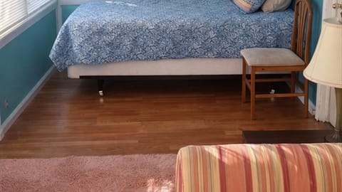 Bedroom with bed, chair, and natural light
