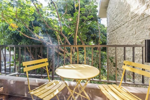 Your private balcony awaits with sunny seating nestled among lush greenery, where morning coffee feels like a tranquil garden escape right from your room.