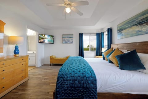 Master King Bedroom with a walk-in closet, TV, and dresser. This spacious room offers comfort and convenience with ample