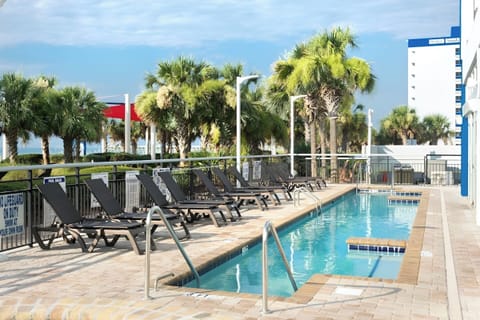 Soak up sunshine beside the palm-lined oceanfront pool.