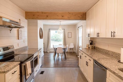 Full kitchen with white shaker cabinets and granite countertops. Goes straight into dining room to enjoy your meals!