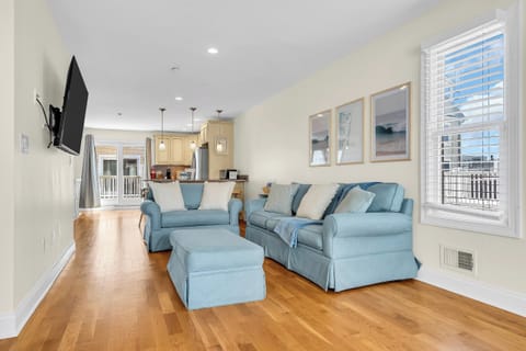 Bright open-concept living room with cozy seating and hardwood floors