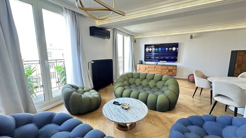 Salon design avec canapé haut de gamme et vue dégagée sur Paris – Appartement 4 pièces en bail mobilité Avenue Hoche Paris 8