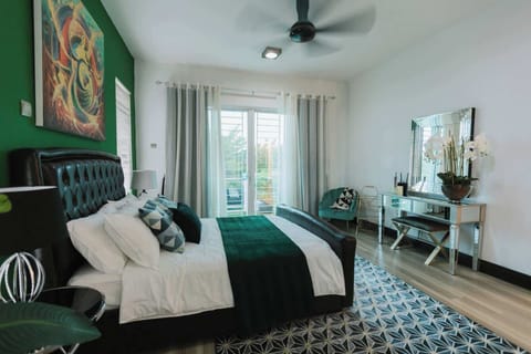 A MASTER bedroom with a queen sized bed and an en-suite with bathtub